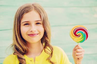 Very nice girl smiling holding up lolipop
